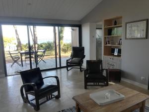 ein Wohnzimmer mit Stühlen und einem Tisch in der Unterkunft Villa Ile de Re avec acces mer du jardin in Rivedoux-Plage