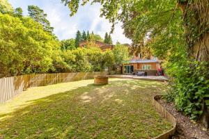 a yard with a fence and a house at Stylish Home - Wentworth, Sunningdale Golf Club in Sunninghill