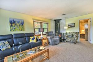 sala de estar con sofá azul y sillas en Charming Gladwin Family Cottage - Indian Lake en Gladwin
