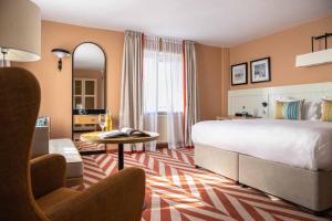 a hotel room with a large bed and a table at The Relais Cooden Beach in Bexhill