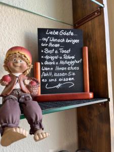 a doll sitting on a shelf next to a chalkboard at Hotel Bannewitz in Bannewitz