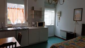 a kitchen with a microwave and a table in a room at Au Relais Des Thermes in Saint-Amand-les-Eaux