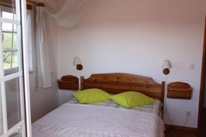1 dormitorio con 1 cama con 2 almohadas verdes en Camping / Appartment Coimbrao en Coimbrão
