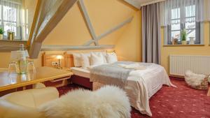 une chambre d'hôtel avec un lit, une table et des chaises dans l'établissement Mühlhäuser Hof- Stadtmauer- Rabe, à Mühlhausen