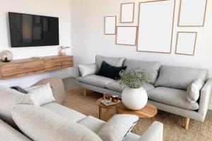 ein Wohnzimmer mit zwei Sofas und einem Fernseher in der Unterkunft KOSI am Meer ZEHN in Ostseebad Koserow