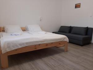 1 cama y 1 sofá en una habitación en Hódvár Apartman, en Tiszafüred