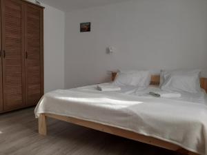 a bedroom with a large bed with white sheets and pillows at Hódvár Apartman in Tiszafüred