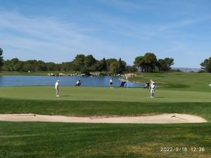 eine Gruppe von Menschen, die auf einem Golfplatz Golf spielen in der Unterkunft Les Coteaux B10 in Mallemort