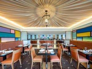 メッカにあるモーベンピック ホテル & レジデンス ハジャル タワー メッカの天井のダイニングルーム(テーブル、椅子付)
