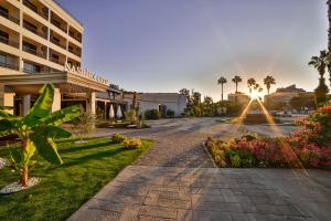 a street in front of a building with the sun setting at Nashira City Resort Hotel in Antalya