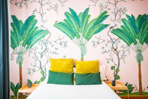 una camera da letto con un letto e un murale di palme di Smartr Madrid Gran Via 47 a Madrid