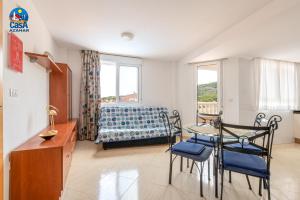 ein Wohnzimmer mit einem Tisch, Stühlen und einem Sofa in der Unterkunft Residencial Marcomar Casa Azahar in Alcossebre