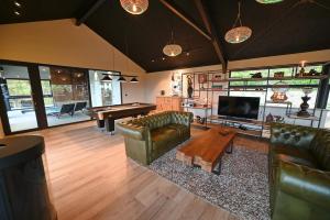 a living room with leather furniture and a pool table at Ard'view in Durbuy