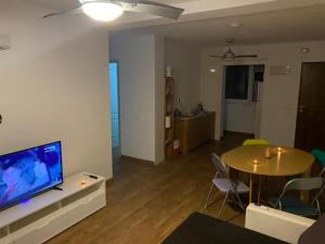 sala de estar con TV, mesa y sillas en CasaAlicante Private Apartment Condo for up to 5 people Zentrale Wohnung AC Bedroom Klimaanlage, en Alicante
