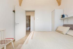 Camera bianca con letto e sedia di Villa Tamerici by BarbarHouse a Torre Vado