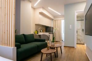 a living room with a green couch and a kitchen at Elegant Suite - Piraeus in Piraeus
