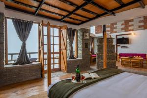 a bedroom with a bed with a bottle of wine and glasses at THE CEDAR CASTLE in Mukteswar