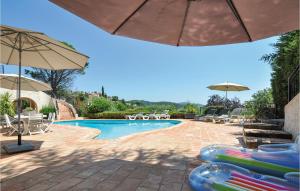 a swimming pool with umbrellas and chaise lounge chairs and a swimming pool at Awesome Home In Les Adrets D Lestrel With 5 Bedrooms, Wifi And Outdoor Swimming Pool in St. Jean de l’Esterel