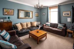 a living room with leather couches and a coffee table at Longsands Lodge in Tynemouth