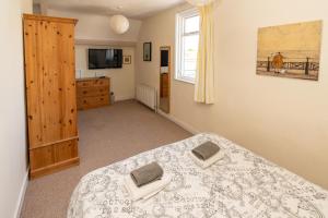 1 dormitorio con 1 cama, vestidor y TV en Longsands Lodge, en Tynemouth