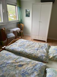 1 Schlafzimmer mit 2 Betten, einem Schrank und einem Tisch in der Unterkunft Wein & Gästehaus Porten-Becker in Köwerich