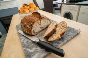 a loaf of bread on a cutting board with a knife at Longsands Lodge in Tynemouth