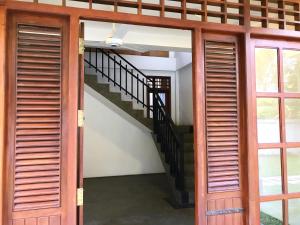 Una escalera en una casa con puerta de madera en Ravan, en Tangalle