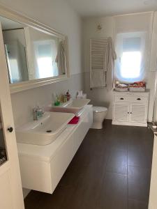 a white bathroom with two sinks and a toilet at Casa hugo olite in Olite