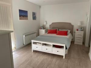 a bedroom with a white bed with red pillows at Casa hugo olite in Olite