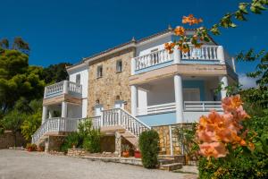 een groot wit huis met balkons en trappen bij Agios Sostis Village Apartments in Laganas