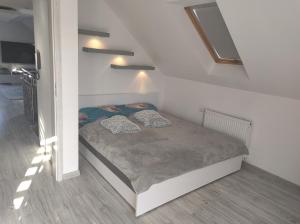 1 dormitorio con 1 cama en una habitación blanca en Pokoje Gościnne U Bosmana en Dźwirzyno