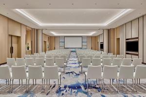 a conference room with white chairs and a screen at Artyzen Habitat Lingang Shanghai in Shanghai