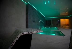 La salle de bains est pourvue d'une baignoire avec un éclairage vert. dans l'établissement OIKOS APARTAMENTOS TURÍSTICOS, à Monesterio