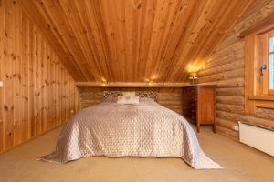 a bedroom with a bed in a log cabin at Alauso Slenis in Sudeikiai