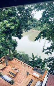 a view of a lake from a deck with tables and chairs at Moonlight Champa Riverview in Luang Prabang