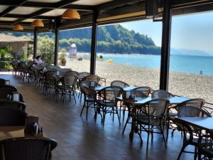 a restaurant with tables and chairs on the beach at Neptun Palace Kvariati in Kvariati