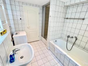 a white bathroom with a sink and a tub at Meißner Elb-Domizil in Meißen