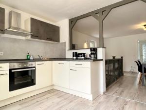 a kitchen with white cabinets and a stove top oven at Meißner Elb-Domizil in Meißen