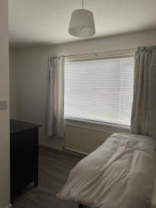 een slaapkamer met een bed en een groot raam bij MACs Belfast in Belfast