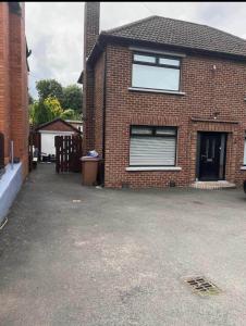 a brick house with a window and a driveway at MACs Belfast in Belfast