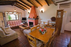 a living room with a table and a fireplace at Villa La Margarita Rocabella in El Chorro