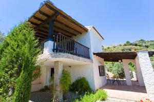 a house with a balcony and a patio at Villa La Margarita Rocabella in El Chorro