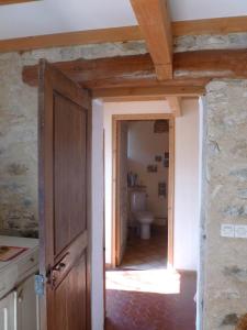 a bathroom with a toilet and a wooden door at belles chambres d'hôte, spacieuses et paisibles, en pays de Forcalquier in Saint-Étienne-les-Orgues