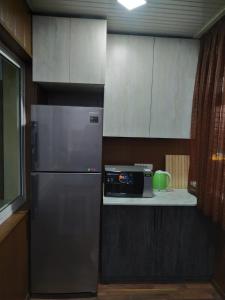 uma cozinha com um frigorífico de aço inoxidável e um micro-ondas em Квартира 2-ух комнатная в центре города em Fergana