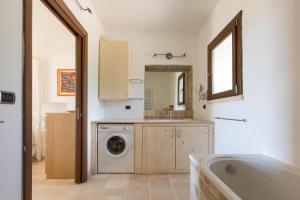 uma casa de banho com uma máquina de lavar roupa e um lavatório em Villa Elaion by BarbarHouse em Marina di Pescoluse