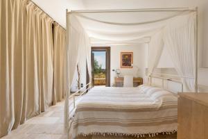 um quarto com uma cama de dossel e cortinas em Villa Elaion by BarbarHouse em Marina di Pescoluse