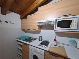 a small kitchen with a microwave and a sink at Dos Torres Ático abuhardillado en Calle Alfonso I in Zaragoza