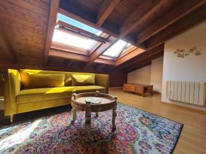 a living room with a yellow couch and a table at Dos Torres Ático abuhardillado en Calle Alfonso I in Zaragoza
