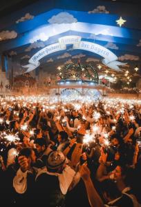 Une foule de gens tenant des étincelles dans un concert dans l'établissement AllYouNeed Oktoberfest camping, à Munich