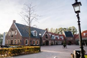 een straatlicht voor een groot bakstenen gebouw bij Othmar Herberg in Ootmarsum